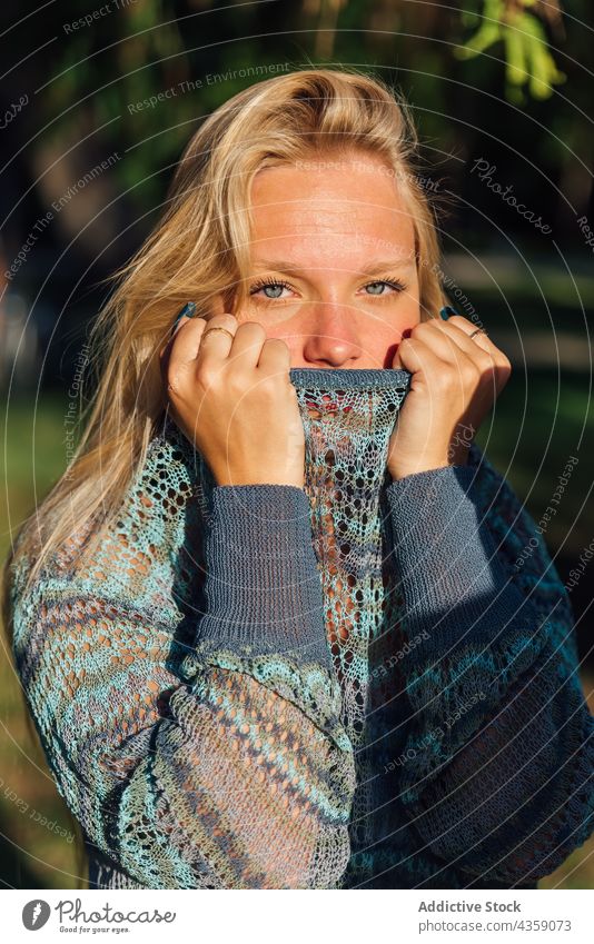 Zarte Frau im Strickpulli im Park bei Sonnenuntergang Pullover Angebot gestrickt gemütlich sanft blond charmant Natur jung Saison ruhig Stil Windstille Harmonie