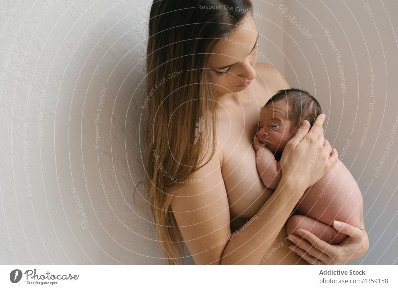 Sanfte Mutter mit schlafendem Neugeborenen zu Hause neugeboren Säugling nackt Zusammensein Liebe Angebot Baby Pflege bezaubernd niedlich heimwärts oben ohne