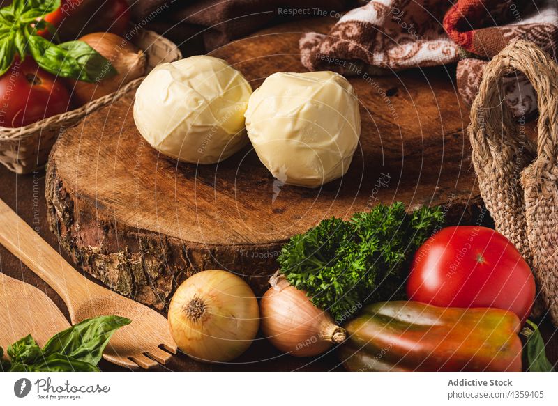 Mozzarella-Käse auf Holzständer zwischen frischem Gemüse und Kräutern Kraut gesunde Ernährung natürlich Öko organisch Spachtel Tasche umweltfreundlich Produkt