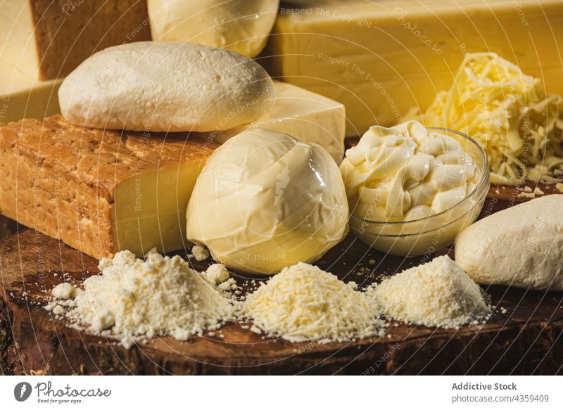 Gemischter ganzer und geriebener Käse auf Holzständer Produkt natürlich Protein Nährstoff organisch frisch Sammlung Bestandteil Taleggio rustikal Öko
