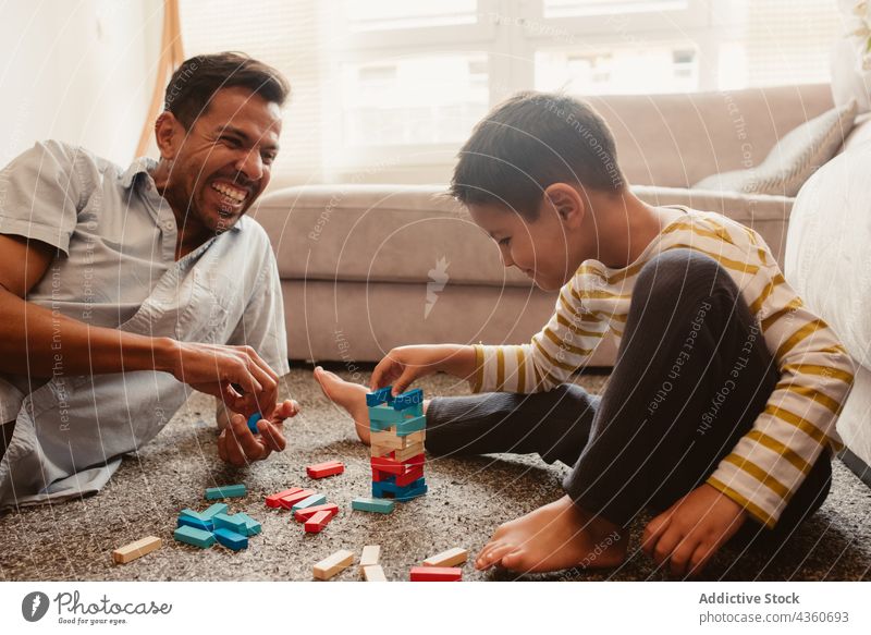 Vater und Sohn spielen mit Bausteinen im Esszimmer Kind Klotz Zusammensein Spielzeug Junge Familie Mann Kindheit Konstruktion Bildung Lächeln bauen Spielfigur