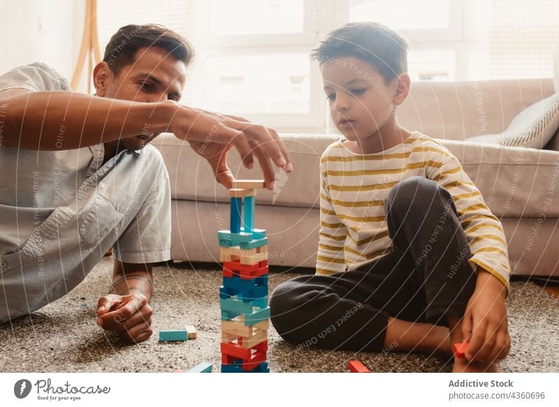 Vater und Sohn spielen mit Bausteinen im Esszimmer Kind Klotz Zusammensein Spielzeug Junge Familie Mann Kindheit Konstruktion Bildung Lächeln bauen Spielfigur