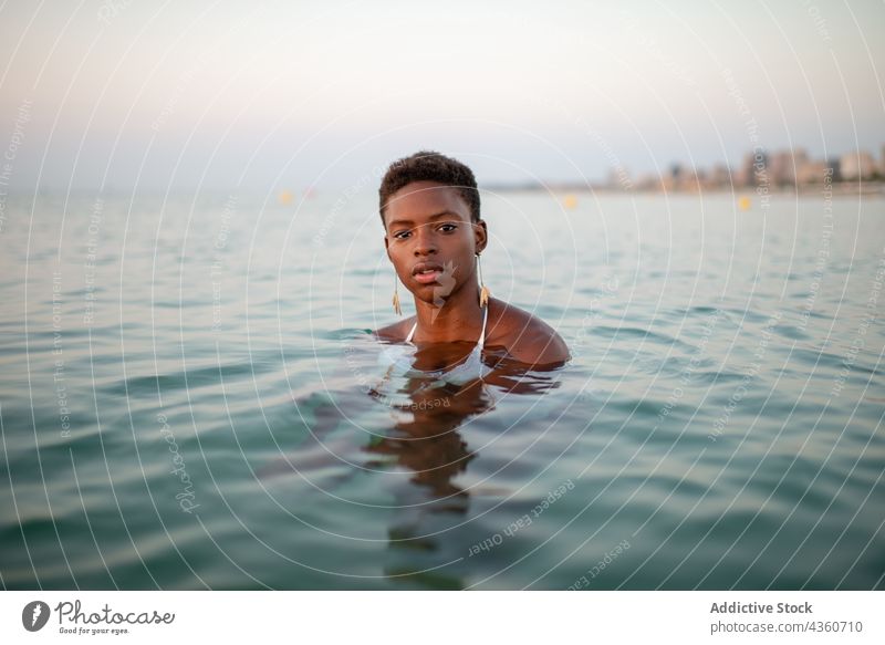 Schwarze Frau mit kurzen Haaren im Meer MEER Wasser Sonnenuntergang Rippeln Abend Sommer ethnisch schwarz Afroamerikaner ruhig schön sich[Akk] entspannen