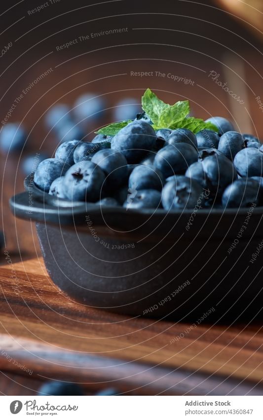 Blaubeeren in einer Schale auf dem Holztisch Beeren Schalen & Schüsseln Lebensmittel Frucht Tisch hölzern blau Gesundheit Dessert Blatt frisch süß saftig