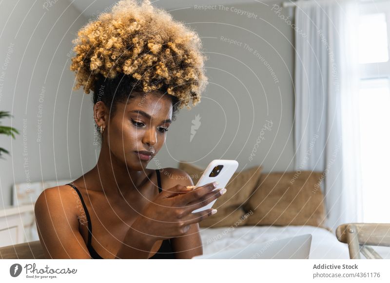 Schwarze Frau benutzt Smartphone im Schlafzimmer benutzend Internet soziale Netzwerke Nachricht zuschauen online Browsen Texten Anschluss Mobile Telefon Surfen
