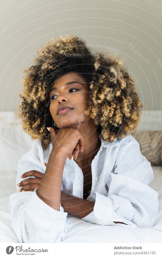 Schwarze Frau auf dem Bett liegend im Schlafzimmer genießen ruhen positiv Komfort sich[Akk] entspannen Morgen Glück heimwärts froh sorgenfrei Frisur ethnisch