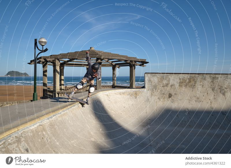 Jugendlicher Skater fährt auf einer Rampe im Skatepark Junge Skateboard Mitfahrgelegenheit Skateplatz Trick Teenager Stunt Seeküste extrem Aktivität