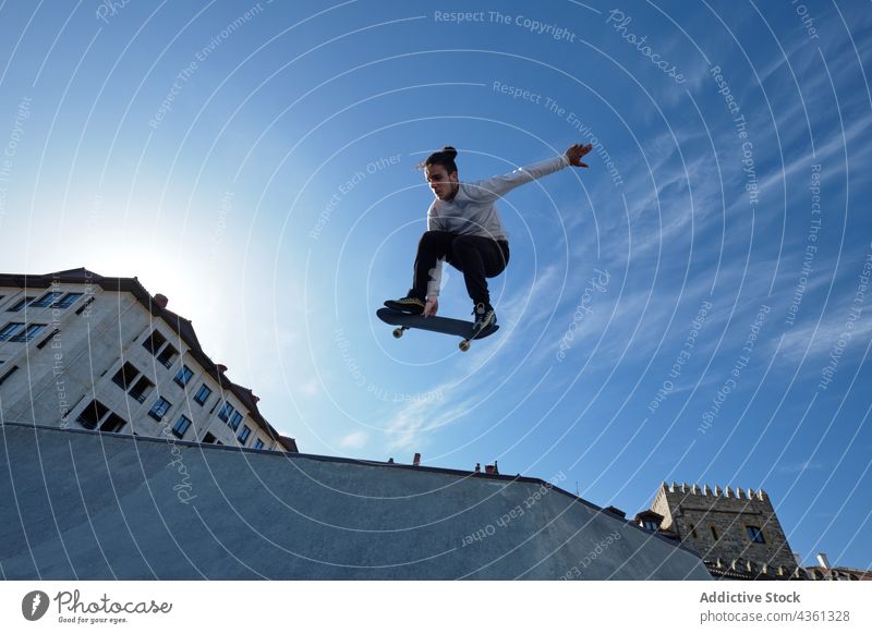 Mann springt mit Skateboard und zeigt Trick in Skatepark Skater springen Skateplatz Stunt Rampe extrem Adrenalin männlich Mut Aktivität Schlittschuh Energie