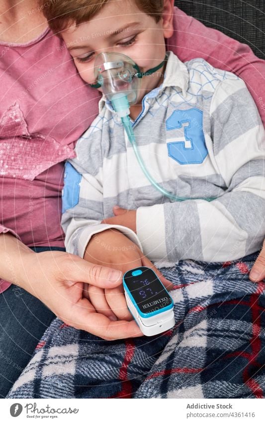 Crop-Mutter mit Pulsoximeter am Finger des Kindes Pulsoxymeter messen prüfen Sauerstoff Blut Prüfung Gesundheitswesen medizinisch Medizin Gerät untersuchen