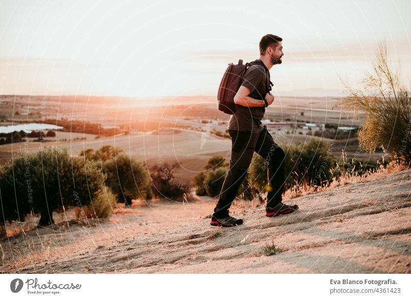 Rucksacktourist Mann wandert auf dem Gipfel eines Berges bei Sonnenuntergang und genießt die Landschaft. Lebensstil und Natur Backpacker Berge u. Gebirge