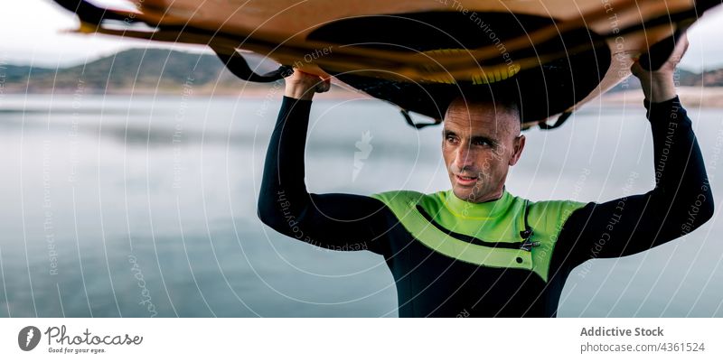 Mann mit SUP-Board steht am Meer Surfer Paddelbrett Zusatzplatine MEER reif Abend Dämmerung Sommer Surfbrett männlich Wasser Ufer Erholung Küste Aktivität Sport