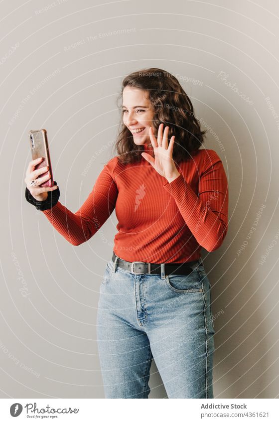 Frau, die einen Videoanruf tätigt, während sie grüßt Person Kaukasier hübsch Glück Videokonferenz Porträt jung schwarz Selfie schön Mobile unter Begrüßung
