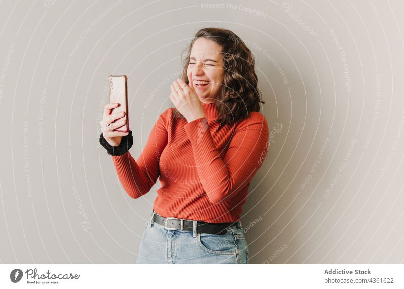 Frau führt lachend einen Videoanruf Person Kaukasier hübsch Glück Videokonferenz Porträt jung schwarz Selfie schön Mobile unter Begrüßung Erwachsener attraktiv