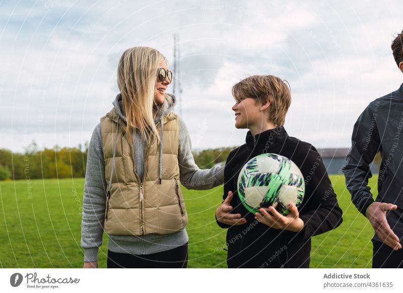 Sportliche Familie versammelt sich auf einem Feld zum Fußballspielen Spieler sportlich sich[Akk] sammeln Wochenende Zeit verbringen Frau Ball Aktivität Gras