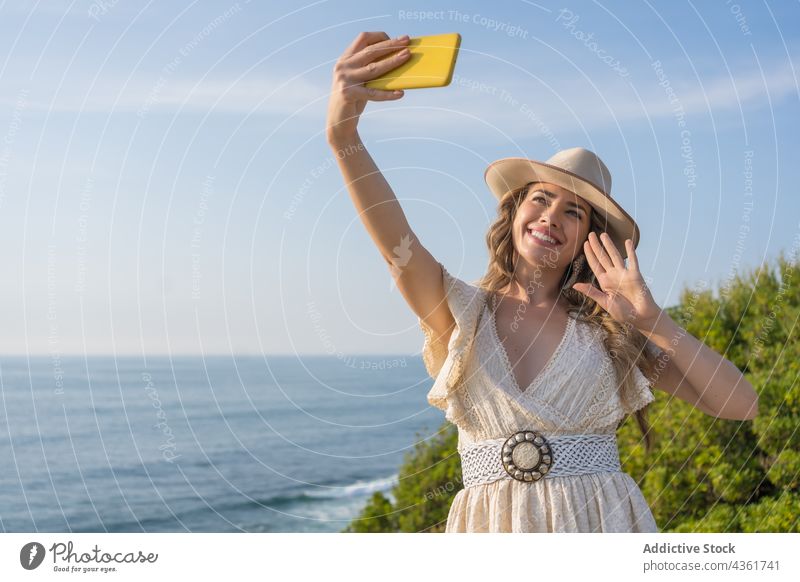 Glückliche Frau macht Selfie am Meer Mode Sommer MEER Stil Smartphone Strand Aussehen Urlaub Reisender jung heiter Feiertag Hut Mobile Telefon Lächeln