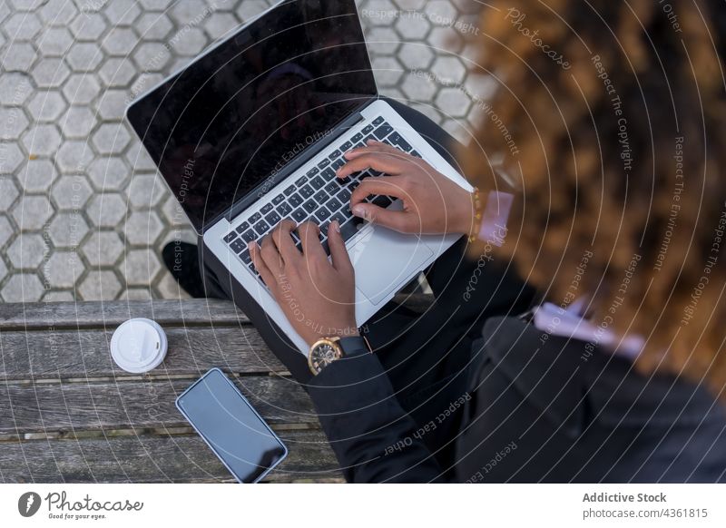 Anonymer schwarzer Geschäftsmann benutzt Computer in der Stadt Tippen Laptop formal benutzend Unternehmer Browsen Surfen Arbeit online Netbook männlich ethnisch
