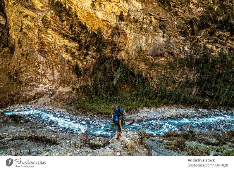 Unbekannter Reisender steht auf einem Felsen in der Nähe eines Flusses in den Bergen Berge u. Gebirge Backpacker Hochland Abenteuer Fernweh reisen