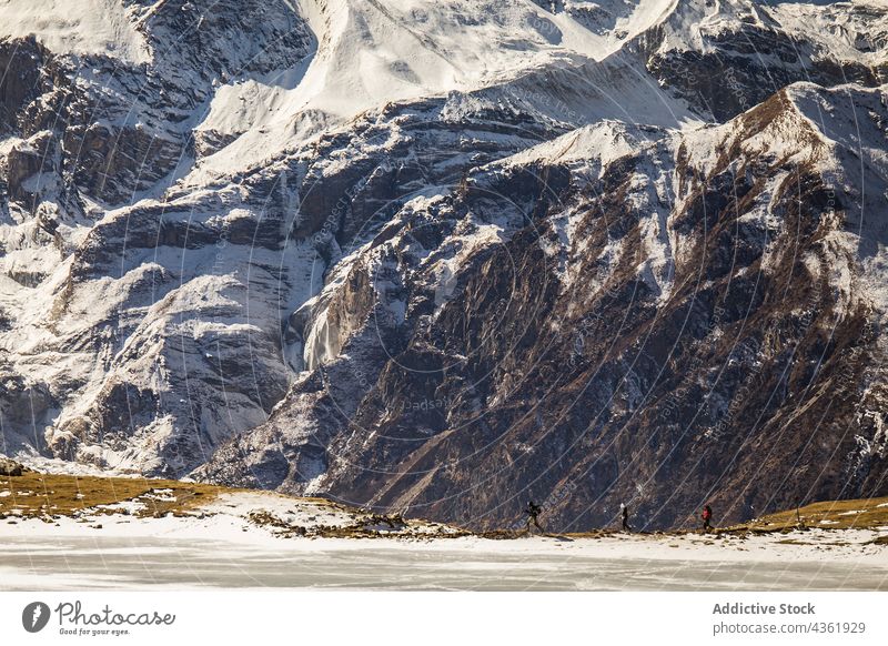 Unbekannte Reisende wandern im Winter durch ein Gebirgstal Reisender Unternehmen Wanderung Berge u. Gebirge Tal Schnee Menschengruppe Hochland Trekking Himalaya