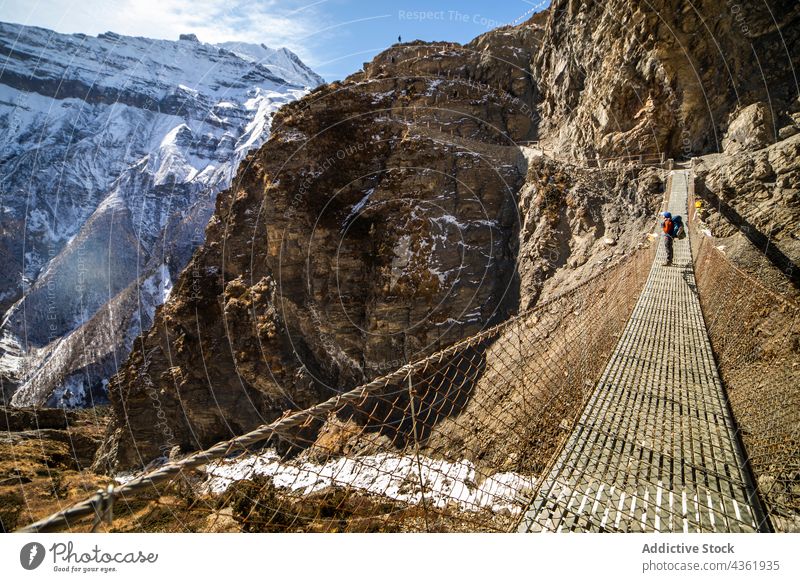 Reisender auf Hängebrücke in bergigem Terrain Berge u. Gebirge Brücke Suspension Hochland bewundern Steg felsig Abenteuer reisen Himalaya Nepal Felsen malerisch