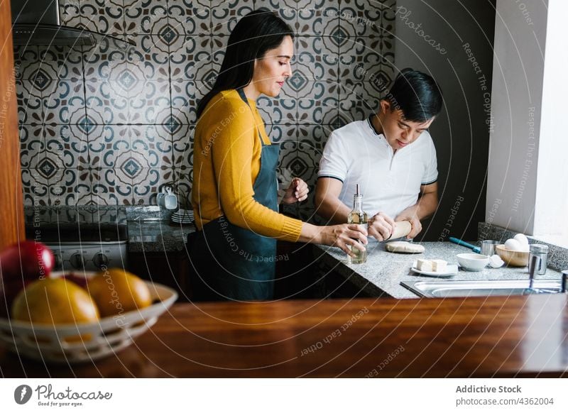 Lateinamerikanische Mutter und Sohn mit Down-Syndrom kochen gemeinsam in der Küche Koch Zusammensein Teigwaren Handicap Lebensmittel Eltern ethnisch