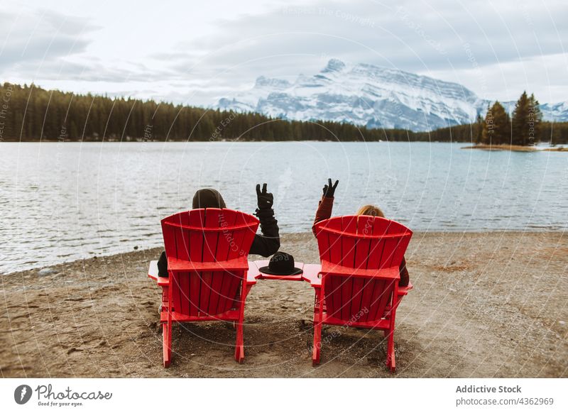 Unbekannte Reisende gestikulieren V-Zeichen in der Nähe des Sees Reisender Ufer Liegestuhl v-Zeichen Zusammensein ruhen Natur Wasser Zwei Jack Lake Alberta