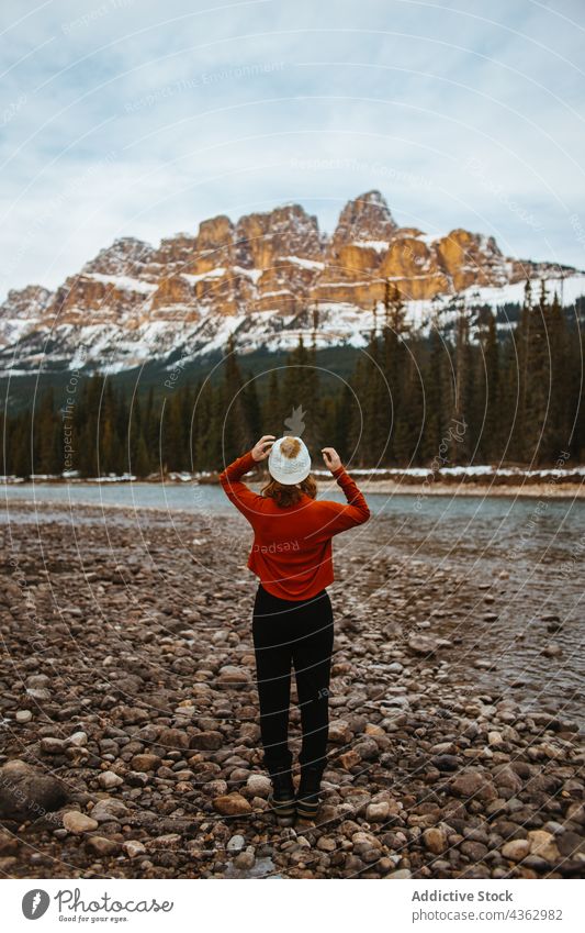 Unbekannte Touristin bewundert Berg und Wald Frau bewundern Berge u. Gebirge Ufer Fluss Natur Baum Schnee nadelhaltig Burgberg Banff National Park Alberta