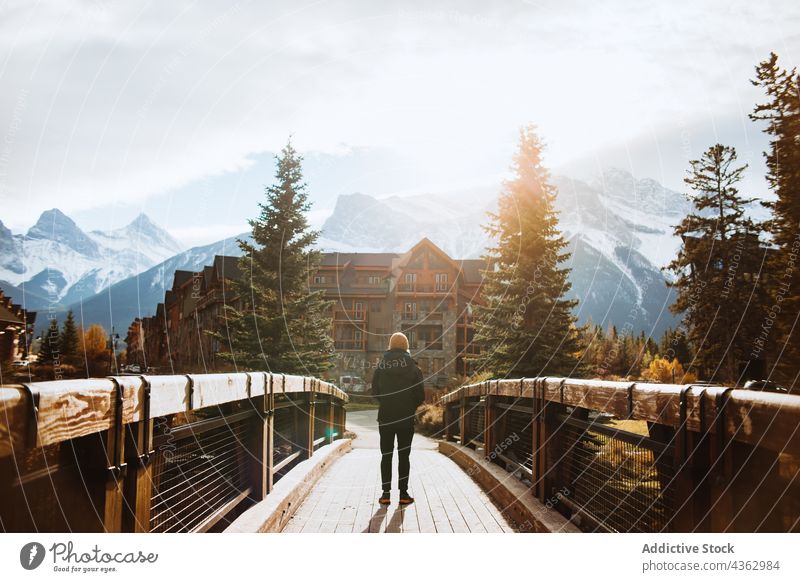 Mann bewundert Berglandschaft von Holzsteg aus Reisender Berge u. Gebirge Natur Brücke Herbst Landschaft erkunden Umwelt männlich reisen Tourismus
