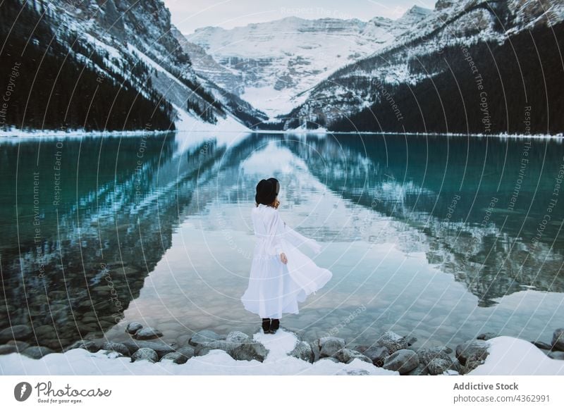 Unbekannte Frau steht im Winter am See Ufer Berge u. Gebirge Natur stehen Schnee kalt reisen Lake Luise Banff National Park Alberta Kanada Wasser Sauberkeit