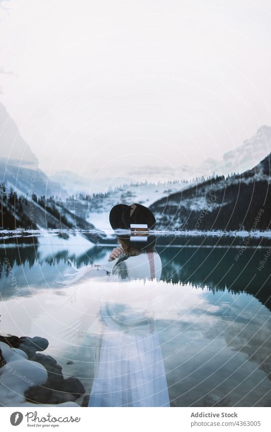 Anonyme verträumte Frau am See im Winter Berge u. Gebirge ruhen Schnee kalt Natur Windstille Lake Luise Banff National Park Alberta Kanada Hut weißes Kleid
