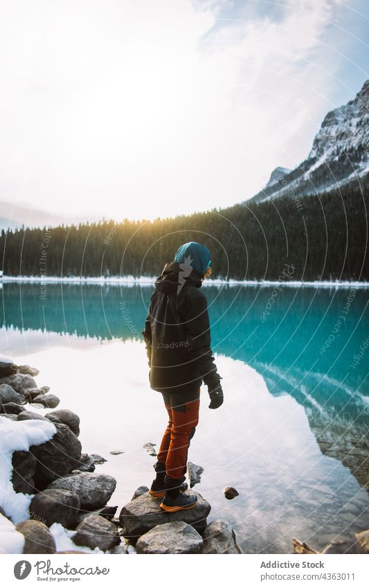 Unbekannter Wanderer steht auf Steinen in der Nähe des Sees Ufer Morgen Natur reisen Winter erkunden Windstille Lake Luise Banff National Park Alberta Kanada