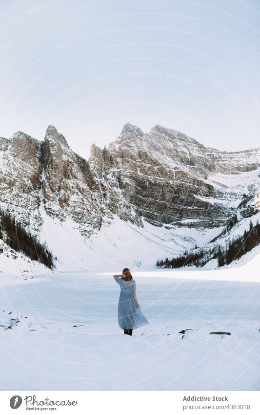 Unbekannte Frau in der Nähe eines zugefrorenen Sees im Winter Ufer Schnee Berge u. Gebirge kalt Natur Saison Lake Luise Banff National Park Alberta Kanada