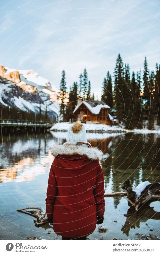 Anonyme Frau am verschneiten Seeufer in der Nähe von Berg und Hütte stehend Tourist Ufer Winter Schnee Berge u. Gebirge bewundern reisen Smaragdsee