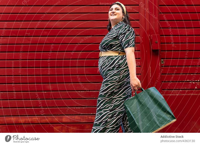 Stilvolle Frau in Übergröße mit Einkaufstaschen kurvenreich Outfit Kleid Mode Geometrie Streifen Glück Werkstatt Ornament jung Model trendy Lifestyle elegant