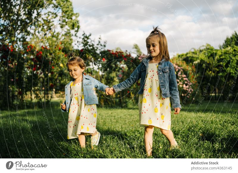 Kleine Mädchen stehen in der Nähe blühenden Busch im Park Blume Sommer Kind wenig Kleid niedlich Blüte Kleinkind Frau Jeansstoff Blütezeit Natur bezaubernd
