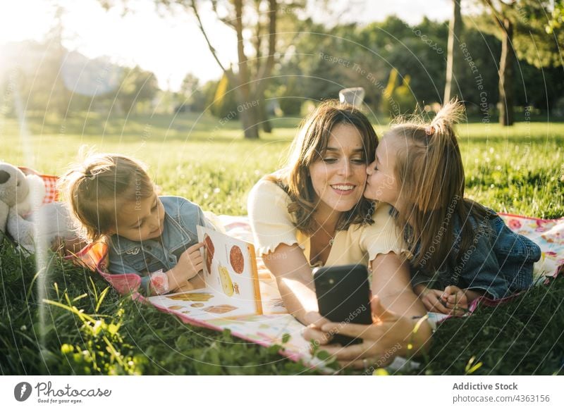 Fröhliche Mutter und Kinder machen ein Selfie im Park Sommer Spaß haben Zusammensein Glück Smartphone Geschwisterkind heiter Liebe Mama Schwester zuschauen