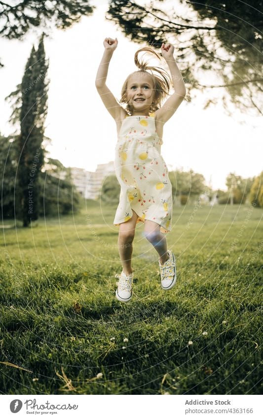 Fröhliches Kind springt auf grüner Wiese Mädchen Sommer Glück springen Park Spaß haben Freude Energie sorgenfrei heiter Frau wenig Vorschule aktiv aufgeregt