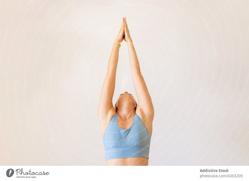 Fit Frau tun Yoga in Mountain Pose mit erhobenen Armen Berg-Pose Namaste Arme hochgezogen üben beweglich Asana Dehnung BH Wellness schlank passen Körper