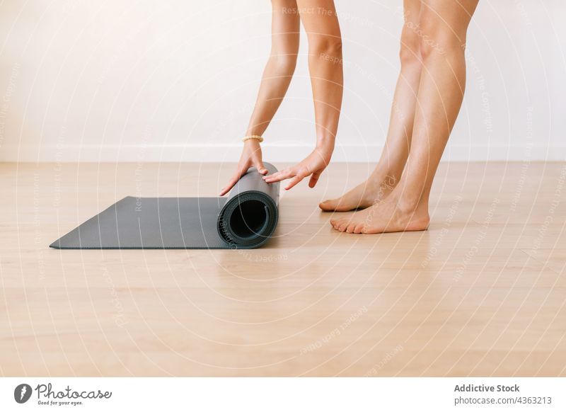 Crop-Frau mit Yogamatte zu Hause Unterlage hochkrempeln heimwärts Zen Achtsamkeit üben Gerät Sportkleidung Barfuß Wohlbefinden Vitalität Gesundheit Wellness