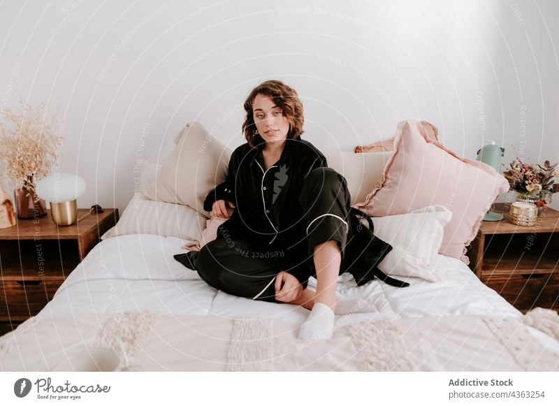 Zarte Frau im Pyjama im Bett sitzend Schlafzimmer Angebot Morgen Komfort gemütlich sich[Akk] entspannen weich wach friedlich Nachtwäsche ruhig Gelassenheit