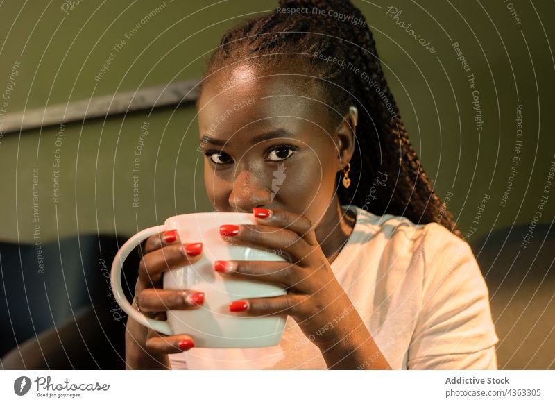 Lächelnde afroamerikanische Frau mit einer Tasse Kaffee in einem Café trinken Kälte heiter Wochenende genießen Getränk ethnisch schwarz Afroamerikaner Becher
