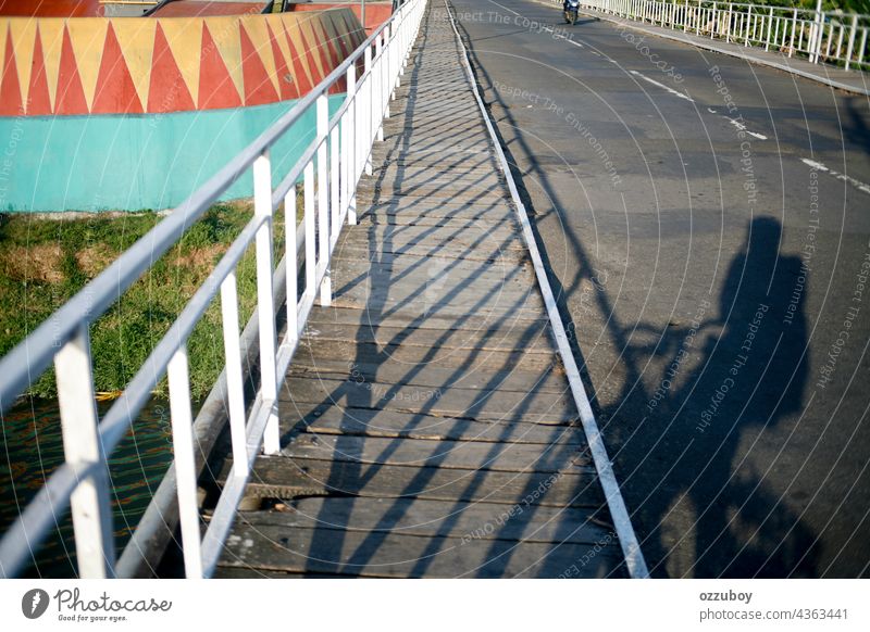 Schatten eines Radfahrers auf der Seite der Brücke Fahrrad Mann Anschluss Transport Fahrradfahren Lifestyle eine Person Gesundheit Menschen Reiten im Freien