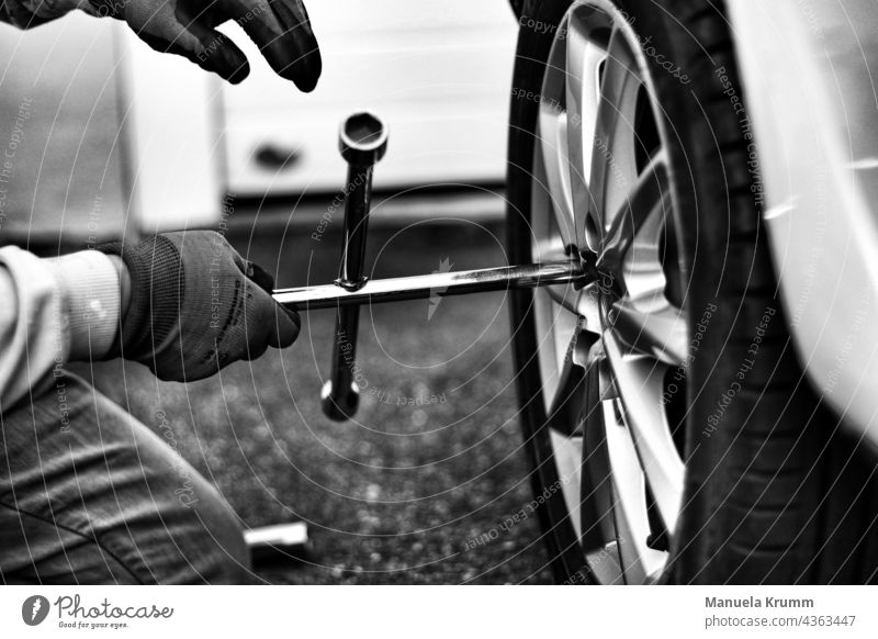 Reifenwechsel reifenwechsel Rad Außenaufnahme Nahaufnahme Radkreuz Schwarzweißfoto Autoreifen Gummi Detailaufnahme schwarz