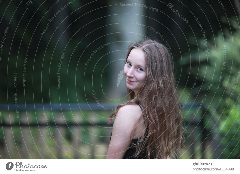 Porträt eines lächelnden Teenager Mädchens mit langen Haaren und flirtendem Schulter-Blick Junge Frau 13-18 Jahre 15-20 Jahre alt 16 16 Jahre Blickkontakt