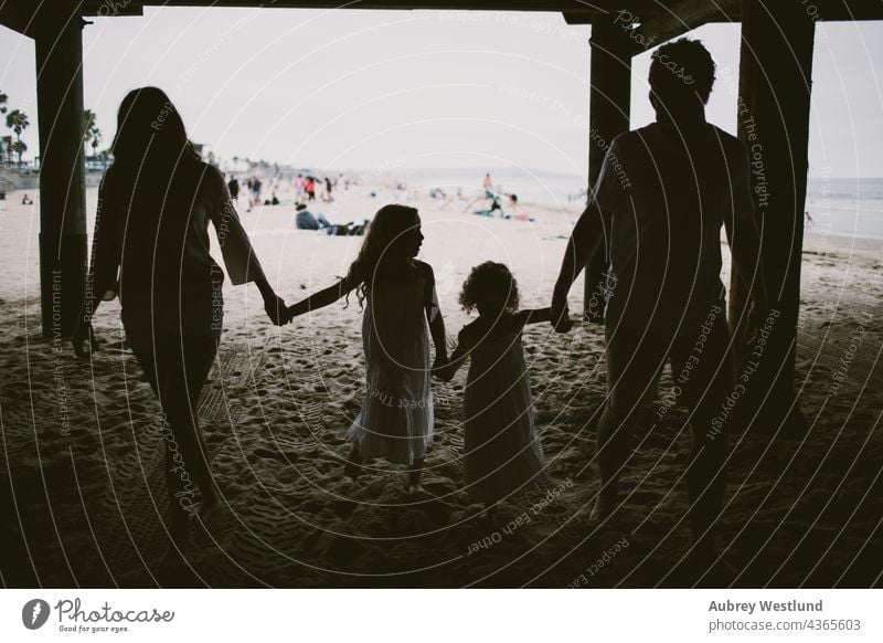 Silhouette einer Familie, die unter einem Steg spazieren geht 0-5 5-10 Strand Kalifornien Papa Töchter fallen Mädchen Händchenhalten Landschaft wenig Mama Meer