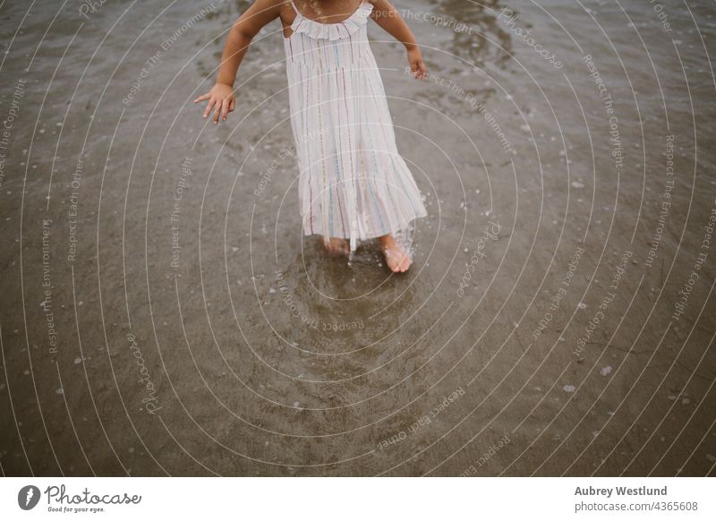 kleines Mädchen, das im Meer spazieren geht 0-5 5-10 Strand Kalifornien krause Haare fallen Familie Landschaft wenig im Freien Pazifikstrand Menschen Pier