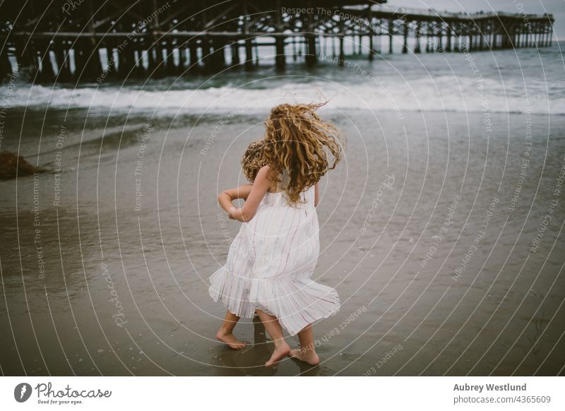 Kleine Mädchen spielen im Meer 0-5 5-10 Strand Kalifornien krause Haare Tanzen fallen Familie Landschaft wenig im Freien Pazifikstrand Menschen Pier spielerisch