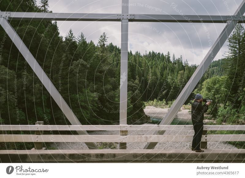Mann filmt Video auf einer Brücke Automobile Kalifornien Fotokamera PKW Küste Filmmaterial Wald Autobahn Berge Mammutbäume Straße Stahl reisen