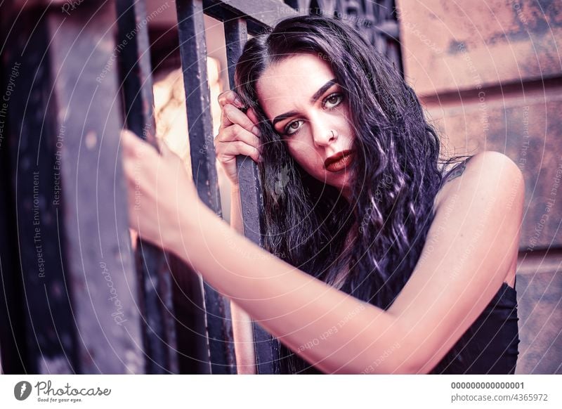 Trauriges Mädchenporträt, das sich an ein Tor klammert urban traurig Frau jung schön Mode Menschen Person Großstadt Straße Schönheit Lifestyle Porträt Kaukasier
