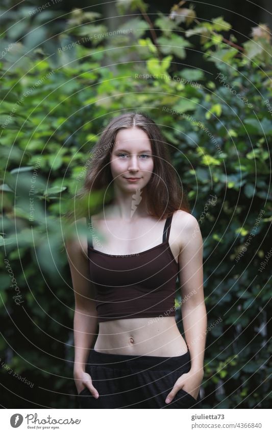 Sommerliches Porträt eines schlanken Teenager Mädchens mit bauchfreiem Top in der Natur Coolness trendy Lächeln Optimismus Zufriedenheit natürlich
