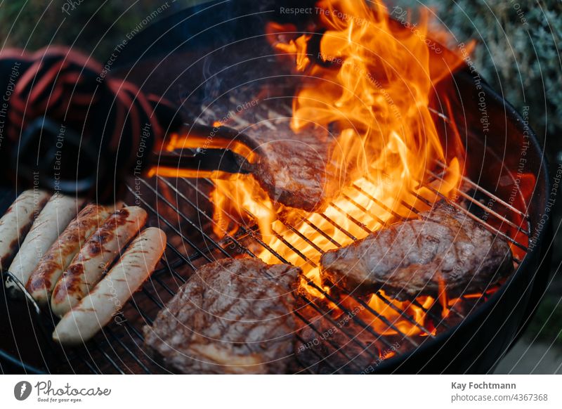 Mann wendet Steak auf dem Barbecue-Grill Grill - Mahlzeit grillen Rindfleisch Kohle Küche kulinarisch lecker Flammen Essen und Trinken glühend Feinschmecker